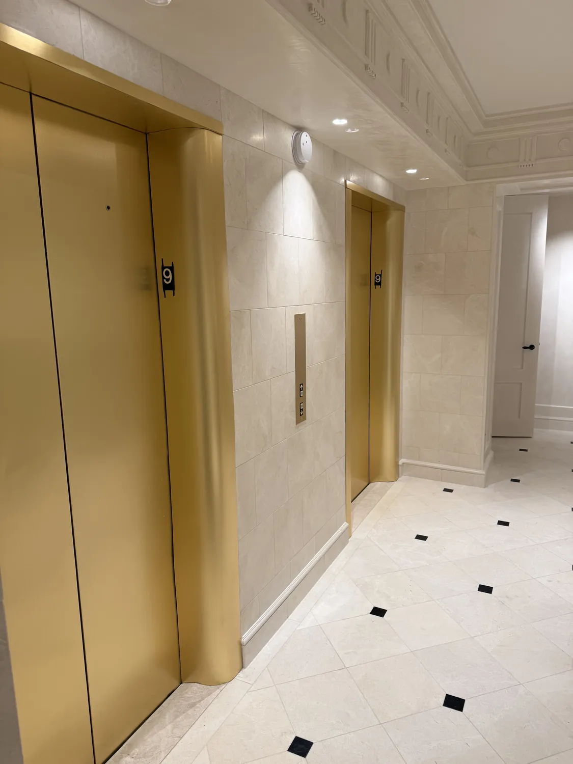Finished elevator and door opening with coordinated frames and surrounding surfaces